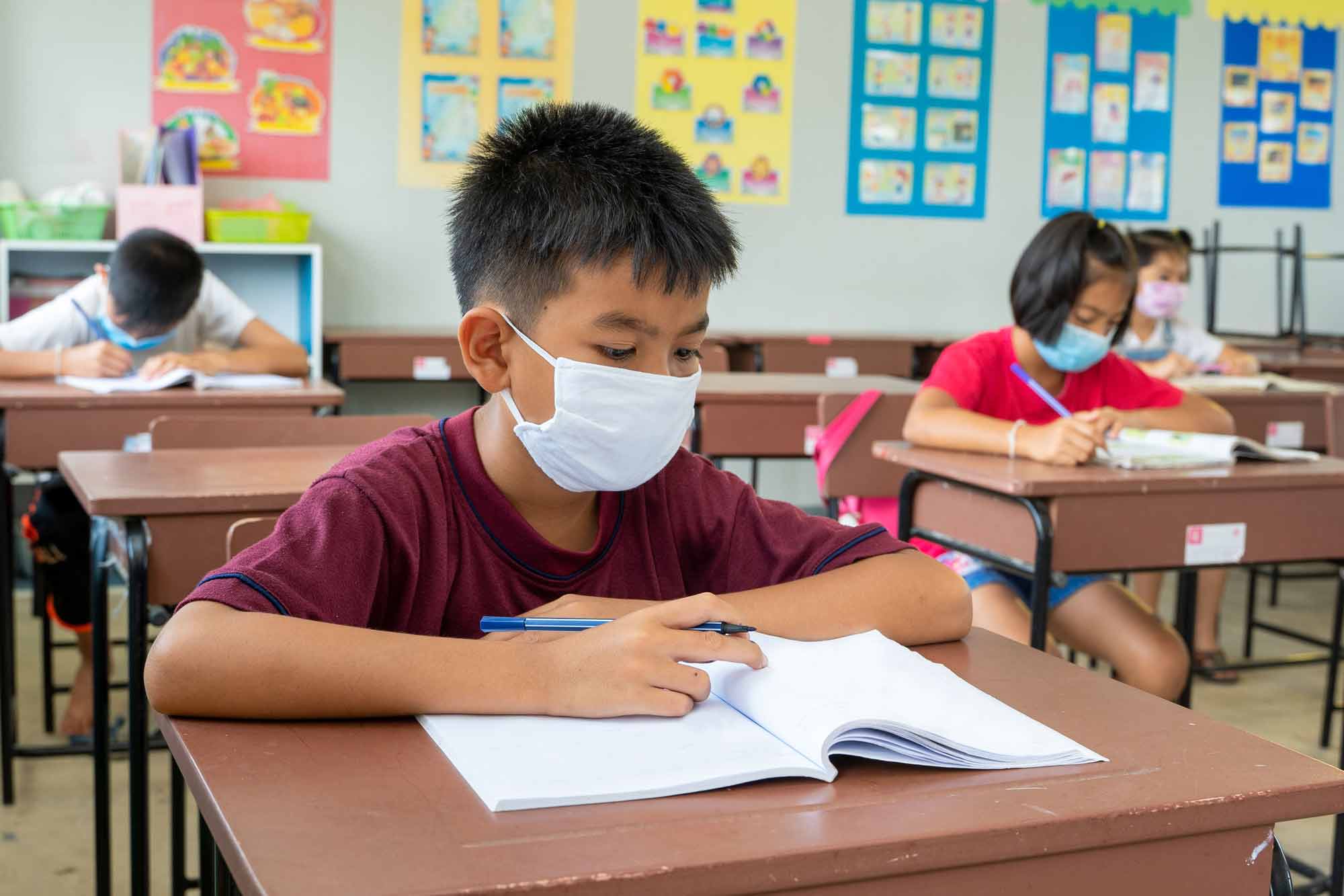 masked student in urban elementary classroom